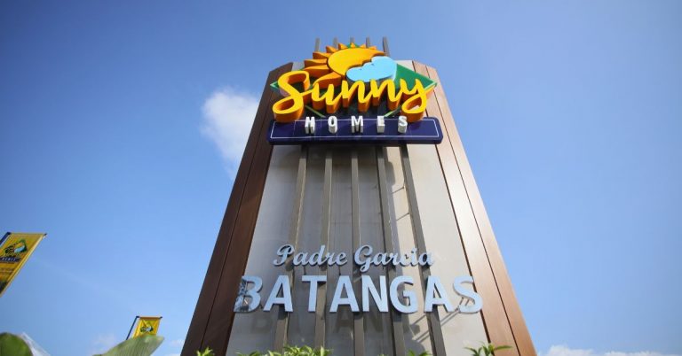 Close-up of the Sunnyhomes signage against a backdrop of clear blue sky, indicating the entrance to the premium residential development in Padre Garcia, Batangas.